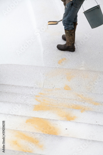 Hand sprinkles dry slippery path in yard with dry sand