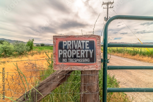 No Trespassing sign at a private property with old wire fence and metal gate