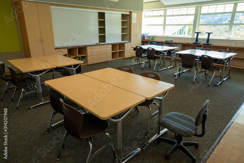 Classroom with empty whiteboard and seats neatly organized with no students © David Tran