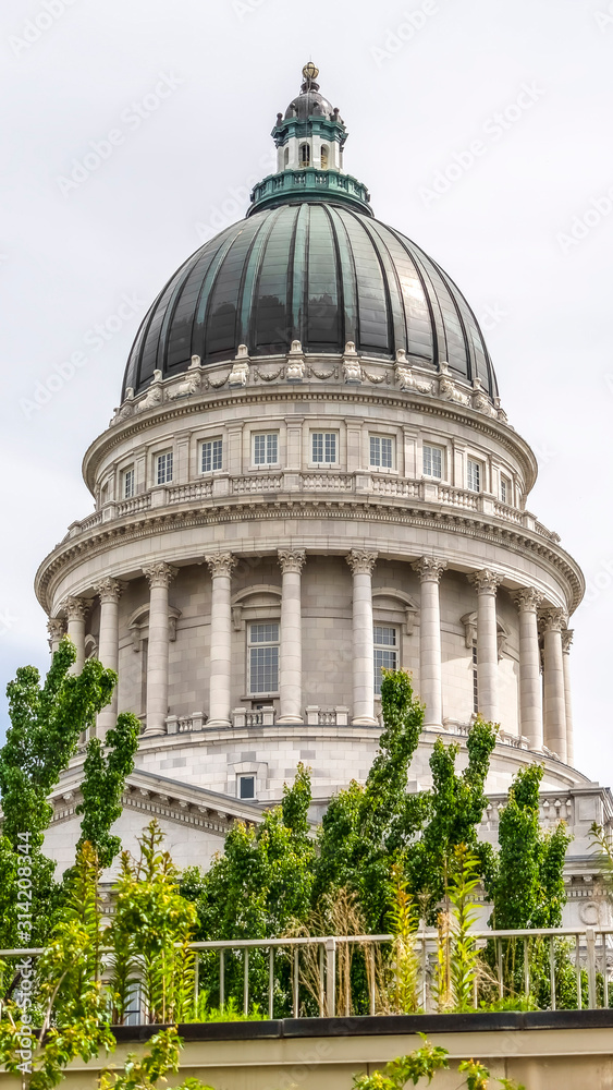 Fototapeta premium Vertical frame Famous dome of Utah State Capitol Building against cloudy sky in Salt Lake City