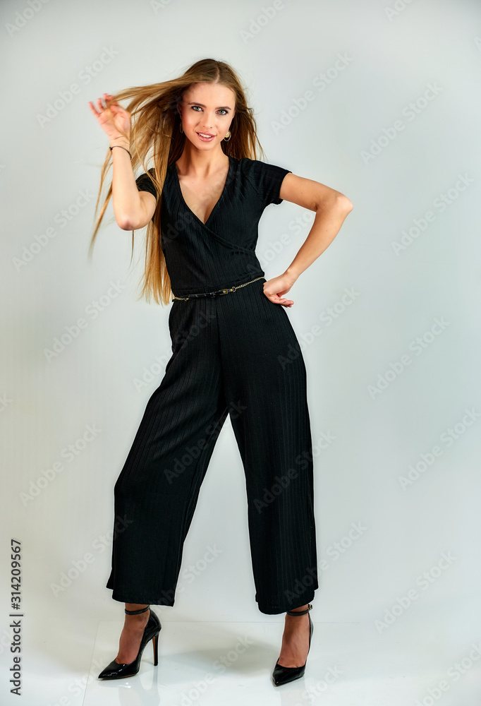 Model student manager stands in different poses in front of the camera in the studio. Full-length portrait of a pretty blonde girl with long hair and excellent make-up on a white background. Model student manager stands in different poses in front of the camera in the studio. Full-length portrait of a pretty blonde girl with long hair and excellent make-up on a white background.