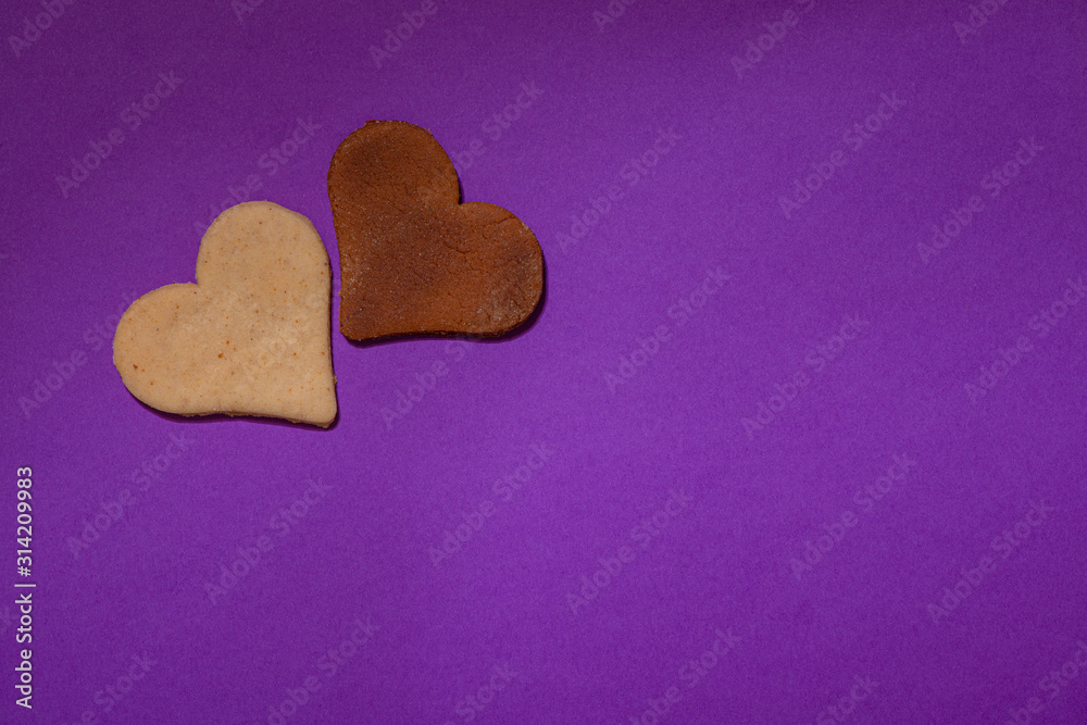 Two heart cookies are on a purple background for Valentine's Day Two heart cookies are on a purple background for Valentine's Day