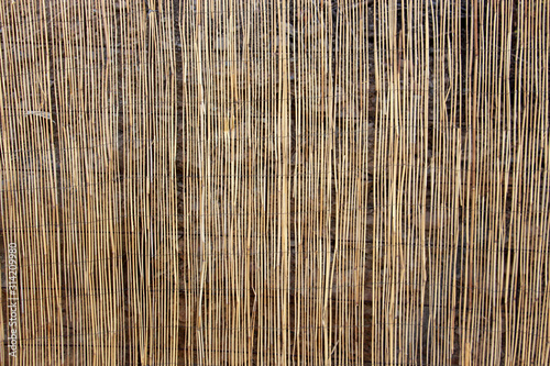 decorative straw fence covering a stone wall