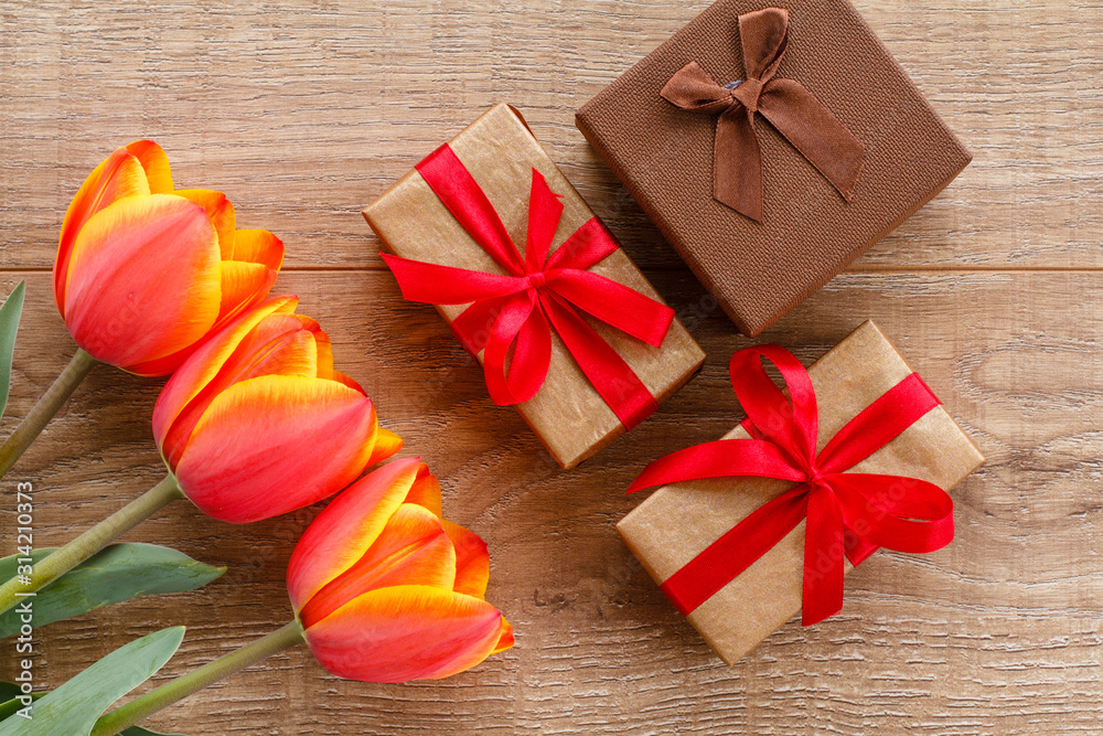 Fototapeta premium Gift boxes with red ribbons on wooden boards.