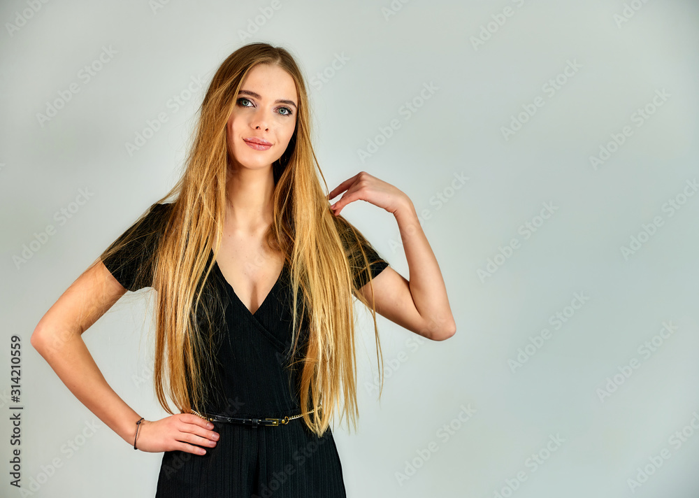 The concept of fashion and style. Portrait of a pretty blonde girl with long hair and great makeup on a white background. The model stands in different poses in front of the camera. The concept of fashion and style. Portrait of a pretty blonde girl with long hair and great makeup on a white background. The model stands in different poses in front of the camera.