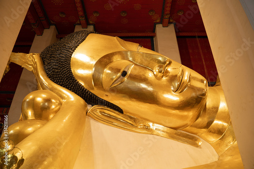 Face of Golden Reclining Buddha at Wat Pha Non Chaksri Temple, Singburi Province, Thailand photo