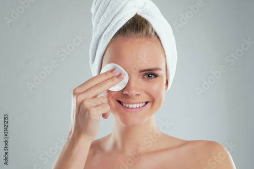 Healthy fresh girl removing makeup from her face with cotton pad. woman with a sponge wihte background cotton pad problem skin