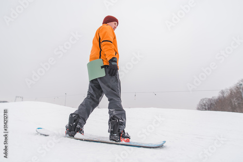 man snowboarding down by hill
