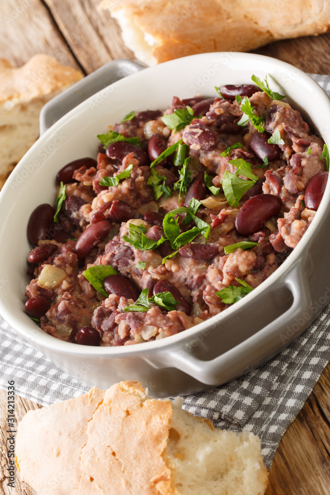 Georgian red bean lobio served with traditional bread close-up in a pan on the table. vertical Georgian red bean lobio served with traditional bread close-up in a pan on the table. vertical