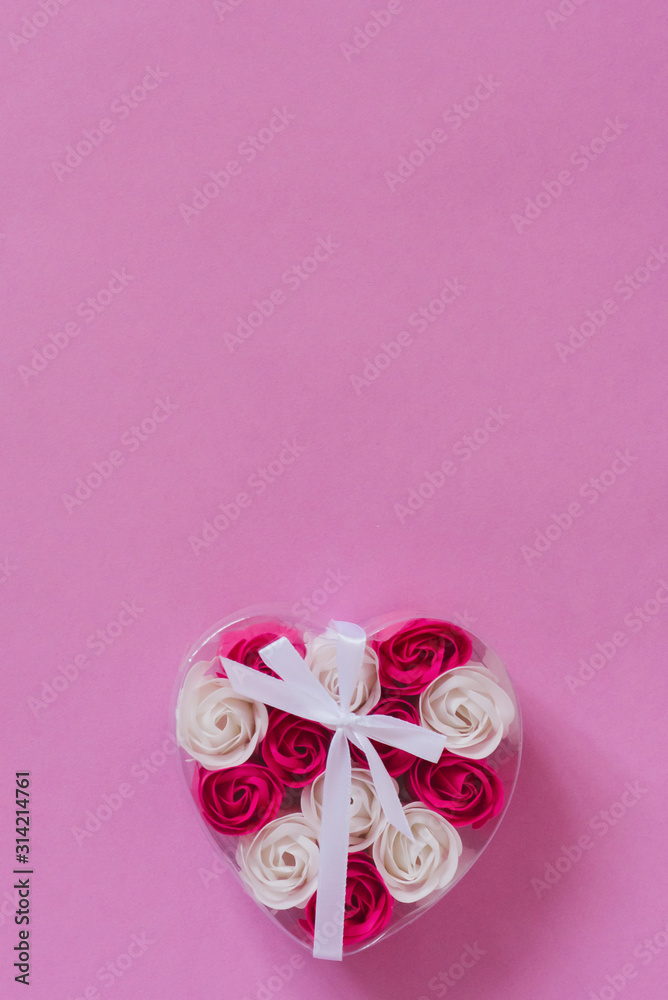 Transparent plastic box with soap rose buds, tied with a ribbon