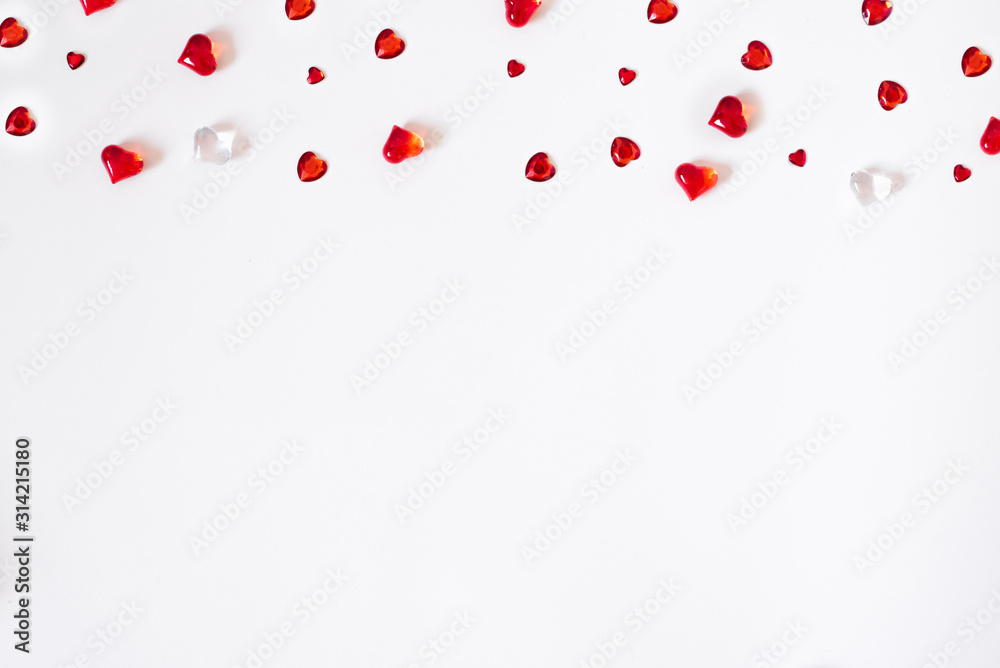 Confetti of red hearts. A scatter of a cornered border on a white Valentine background