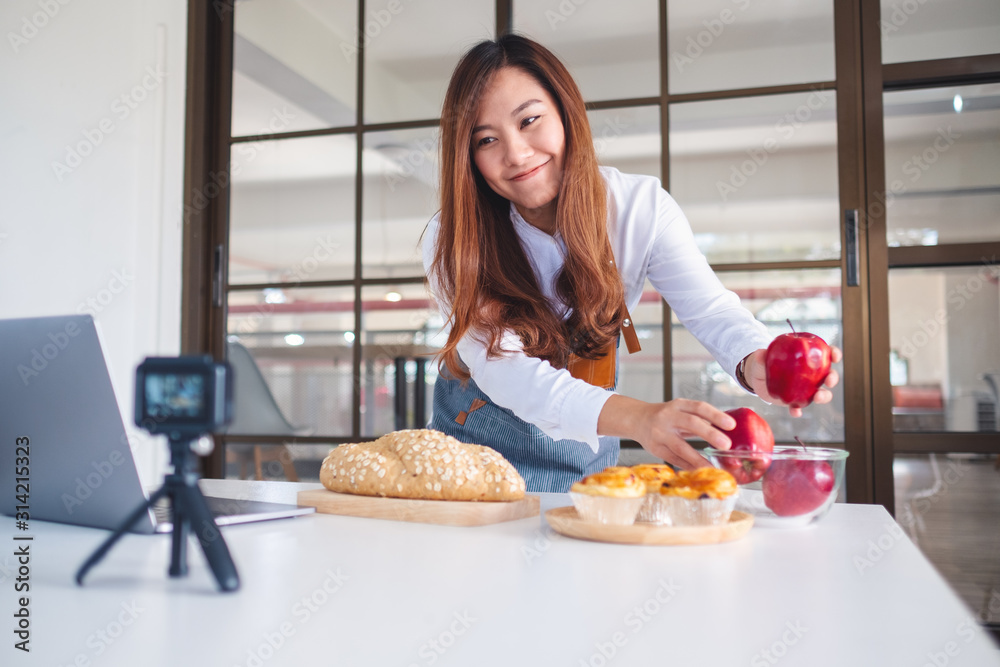 A beautiful asian woman food blogger or vlogger recording a video on camera A beautiful asian woman food blogger or vlogger recording a video on camera