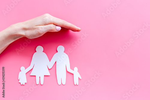 Live insurance concept. Family silhouette under palm on pink background top-down copy space