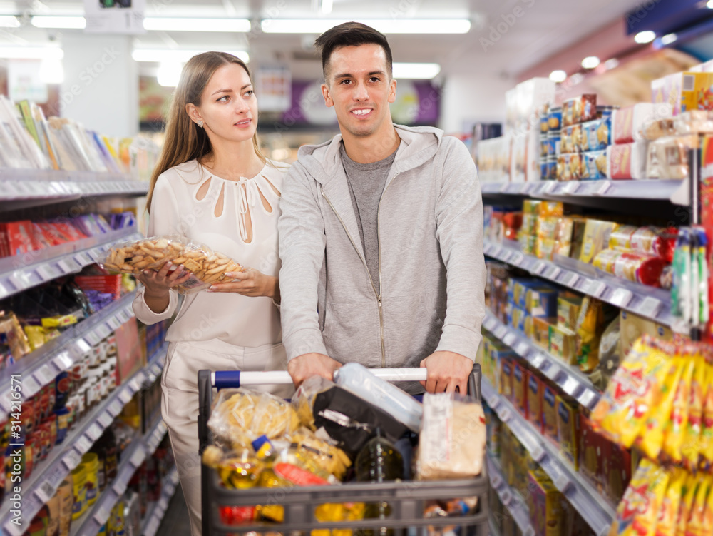 Couple shopping crackers and snacks