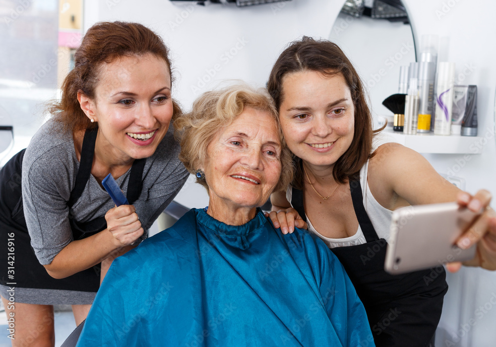 Obraz premium Hairstylists and female customer taking selfie