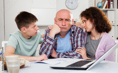 Chagrined family analyzing finances