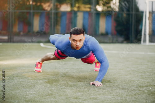 Man training. Guy in a sports clothes. Male in a summer park © hetmanstock2