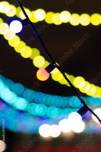 Abstract background with colored Garland light bokeh in dark. Bokeh abstract for background.