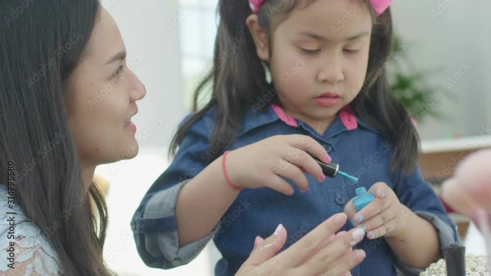 The child with Sister are painted with fingernails. The girl paints a little girl's fingernails. The child with Sister are painted with fingernails. The girl paints a little girl's fingernails.