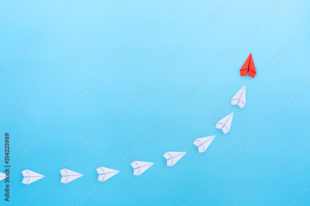 Leadership concept with red paper plane leading among white paper planes on blue background. copy space - obrazy, fototapety, plakaty 
