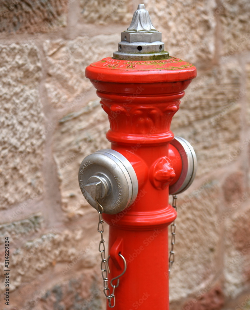 Roter Hydrant mit silbernen Schlauchanschlüssen Roter Hydrant mit silbernen Schlauchanschlüssen