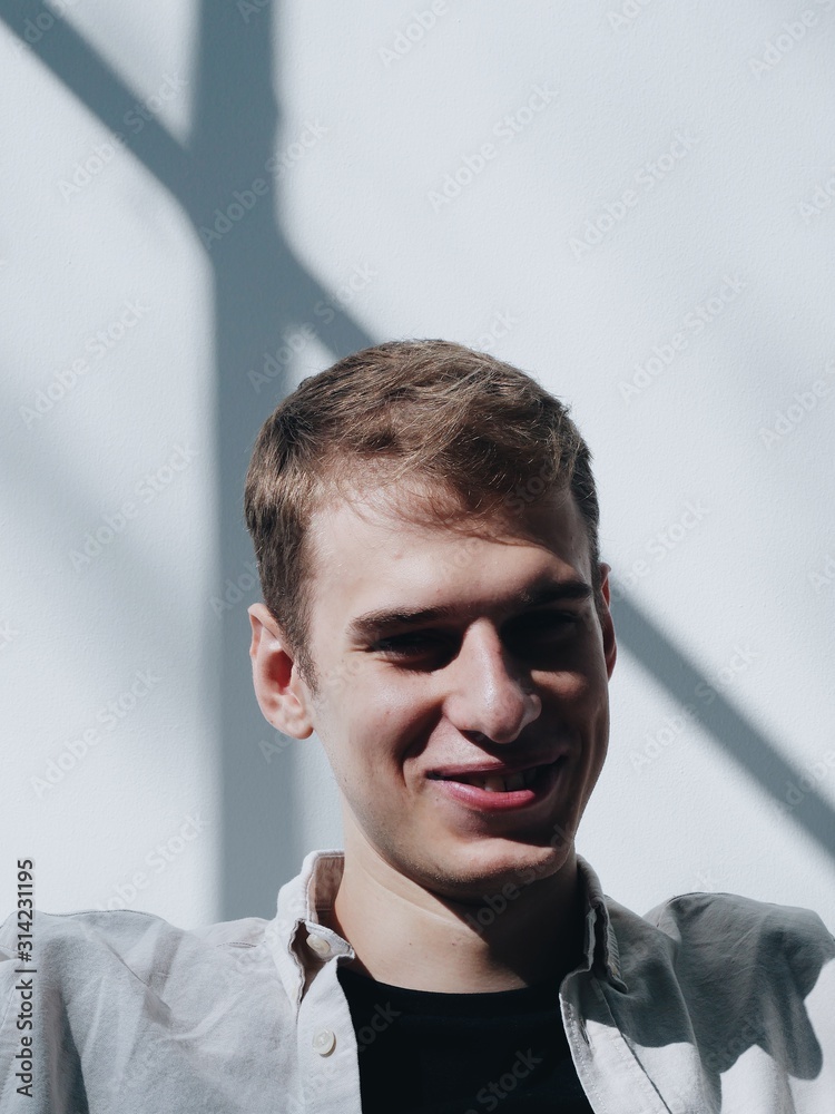 Portrait of laughing guy covered with shadow at sunny day. Vertical photo Portrait of laughing guy covered with shadow at sunny day. Vertical photo