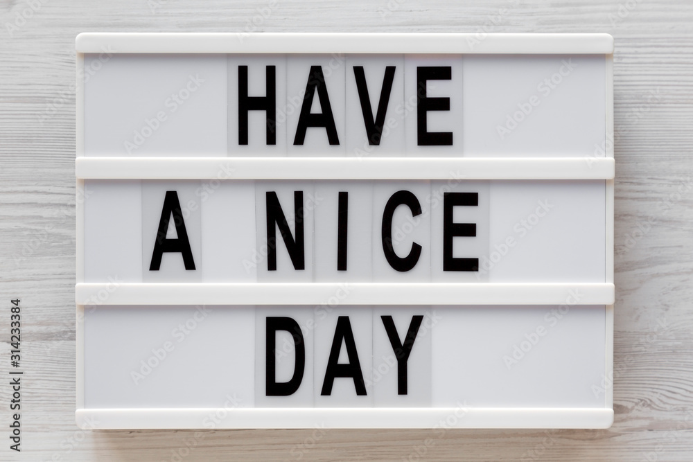 'Have a nice day' words on a lightbox on a white wooden background, top view. Overhead, from above, flat lay. Close-up. 'Have a nice day' words on a lightbox on a white wooden background, top view. Overhead, from above, flat lay. Close-up.