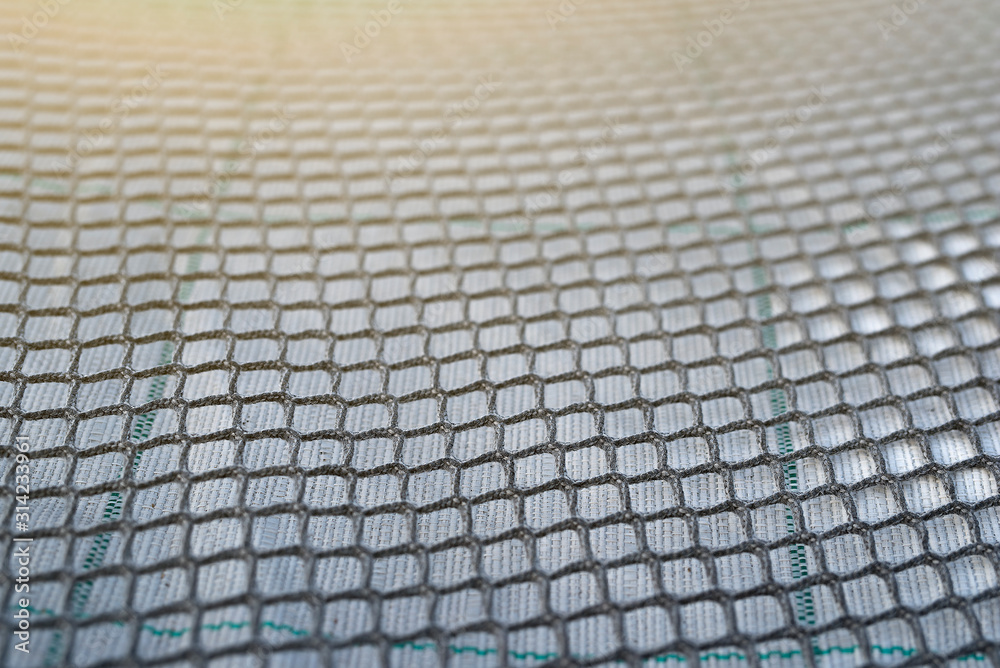 Close up view of fishing net in marine port in the morning. Selective focus. Blurred pattern background