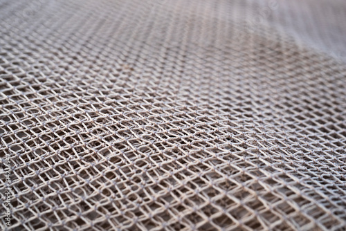 Close up view of fishing net in marine port in the morning. Selective focus. Blurred pattern background