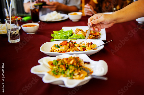 Families eating food together who are happy to eat many cuisine on the table