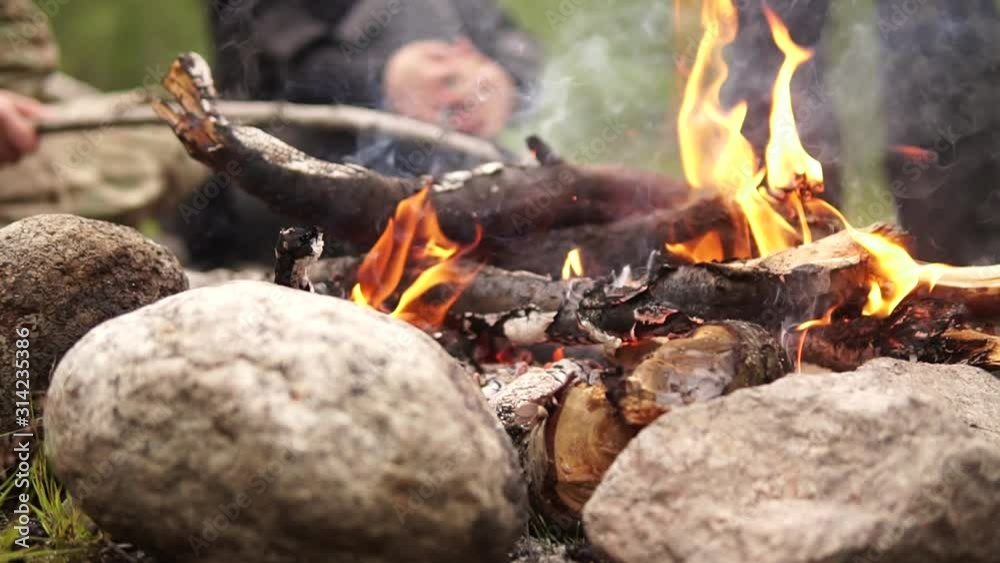 Сlose up. people sitting around campfire Сlose up. people sitting around campfire