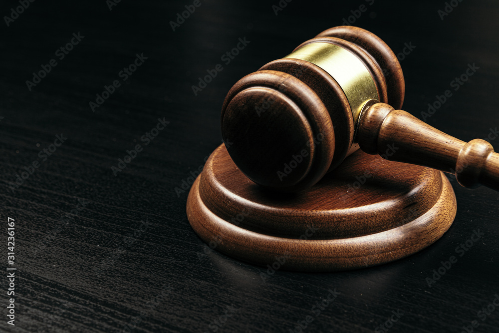 Judge's gavel on wooden table in dark Judge's gavel on wooden table in dark