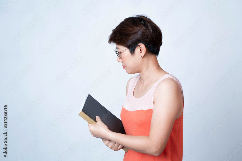 Portrait of an Asian short haired woman holding a book on a white background Portrait of an Asian short haired woman holding a book on a white background