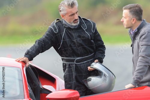 man talking to racing driver