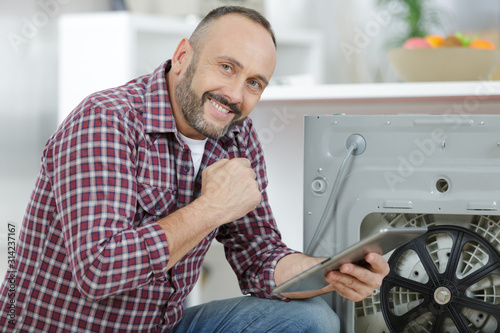 man using digital tablet at laundry