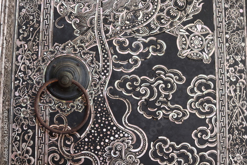 Fotografie Old style iron door knob is on Thai painting ancient door of church in temple, Bangkok, Thailand