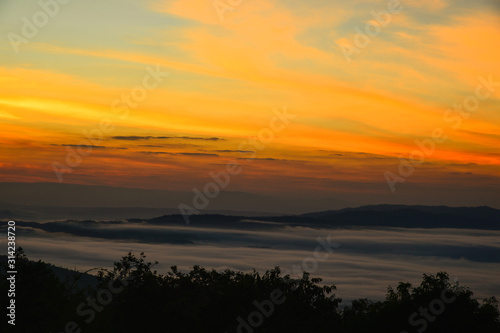 Stunning amazed natural landscape of sun rising above mountain and sea of mist in the fresh morning on high mountain in Thailand. © Jack Tamrong
