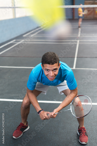 portrait of young male badminton player crouched into position © auremar