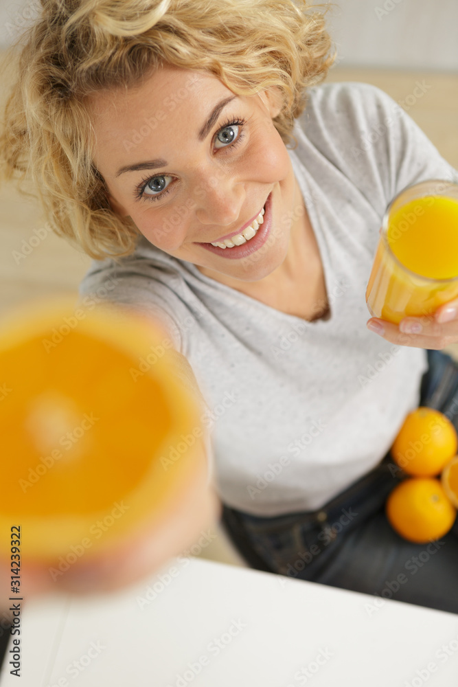 woman with juice glass and oranges on wooden background woman with juice glass and oranges on wooden background