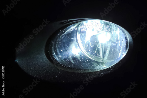 Fotografie The xenon lamp in car's headlight glows.