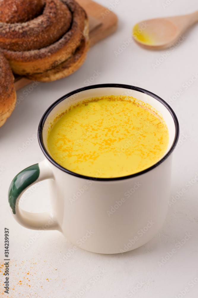 healthy drink golden milk next to breakfast rolls. vertical photo healthy drink golden milk next to breakfast rolls. vertical photo