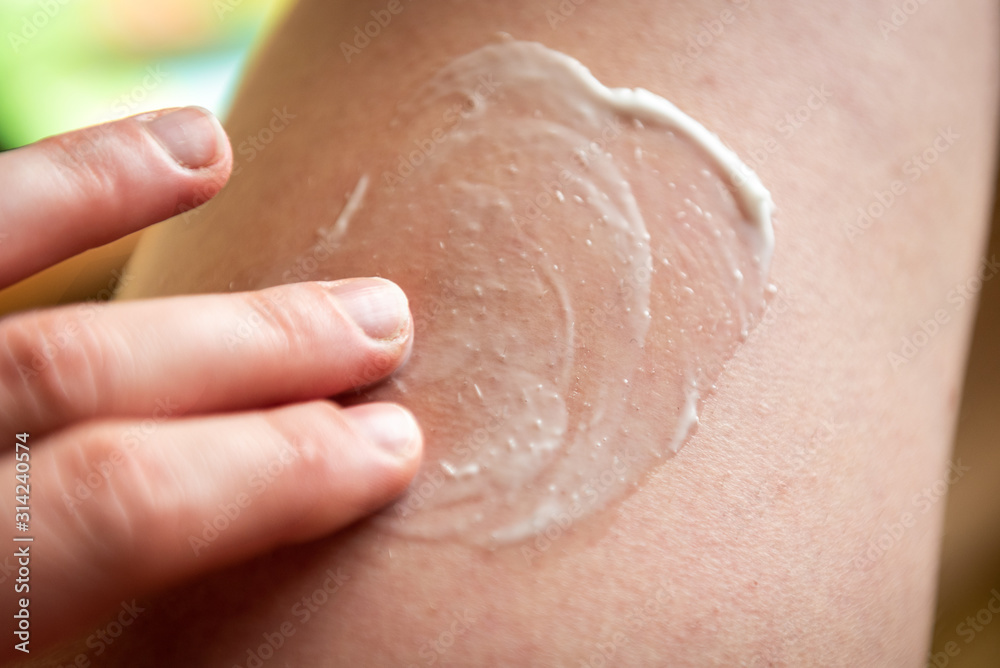 Fototapeta premium Hand applying the cream on skin.