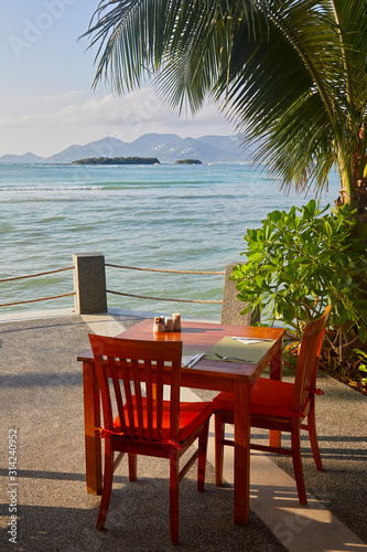 Fototapeta Naklejka Na Ścianę i Meble -  Table with chairs for Breakfast on a sea background