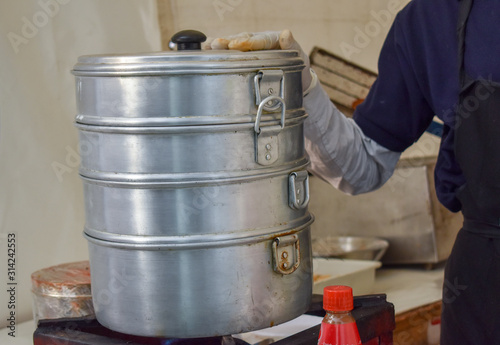 Man holding steam cooker for cooking momos