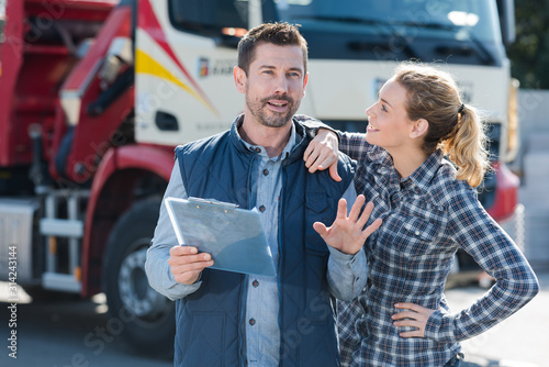Bilde på lerret jovial man and woman in front of transport lorry