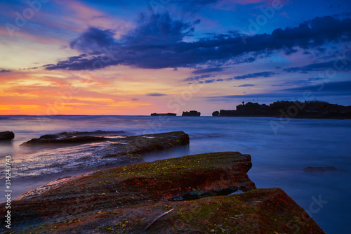 Sunset view at the ocean coast line at Bali black sand beach long exposure