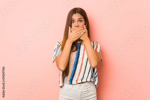 Young slim woman shocked covering mouth with hands.