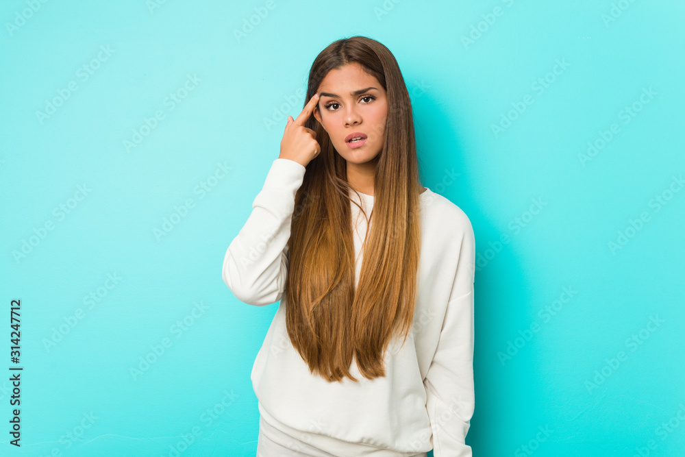 Young slim woman showing a disappointment gesture with forefinger.