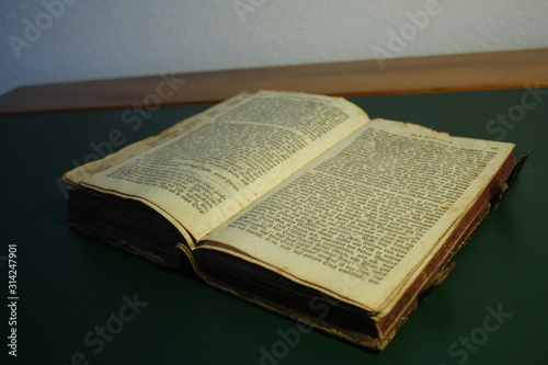 Sehr altes Buch aufgeschlagen auf einem Tisch