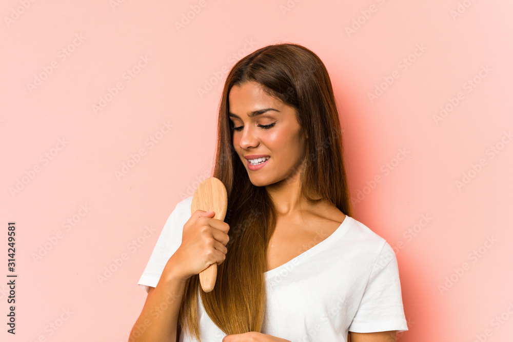 Young caucasian woman holding a hair brush isolated Young caucasian woman holding a hair brush isolated